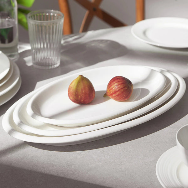 White ceramic platter with two figs on a light gray surface
