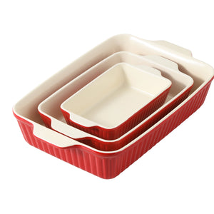 Set of three red and ceramic baking dishes on a white background