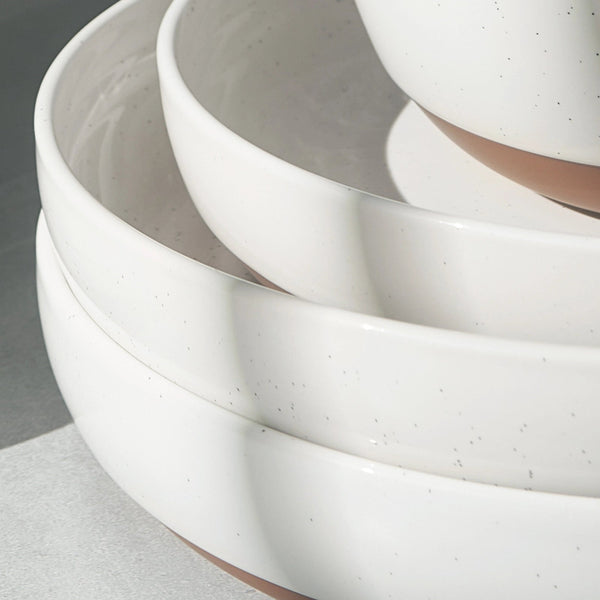 Stack of white ceramic bowls on a gray surface