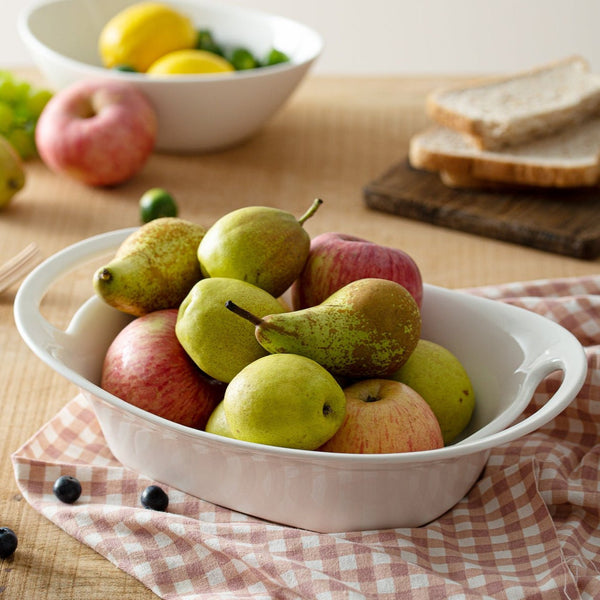 White bowl with pears and apples on a checkered cloth